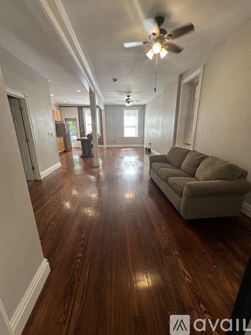 A living room with a couch and a ceiling fan.