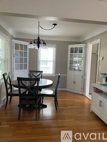 A dining room with a round table and chairs.