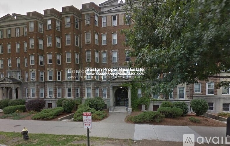 A street view of a multi-story building with a sign in front that says "Bost of Boston Proper Real Estate".