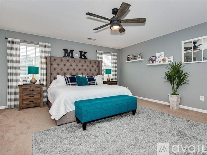 A bedroom with a bed, nightstand, and a ceiling fan.
