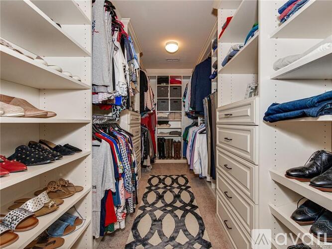 A spacious walk-in closet with neatly organized shelves and a variety of shoes and clothing.