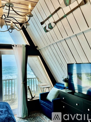 A bedroom with a large bed and a balcony overlooking the ocean.