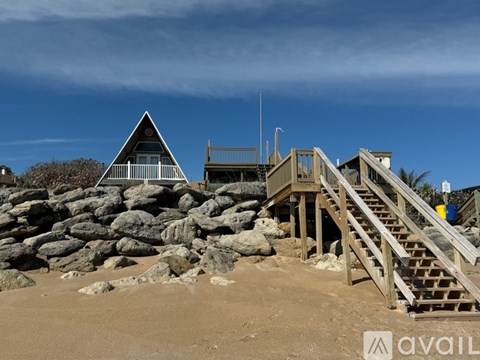 A beach scene with a wooden staircase leading to a building.