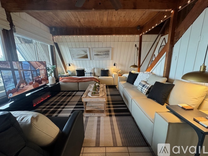 A living room with a couch, a coffee table, and a television.
