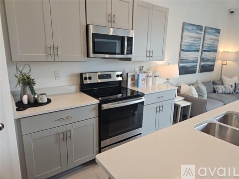 A modern kitchen with a stove top oven and microwave above the counter.