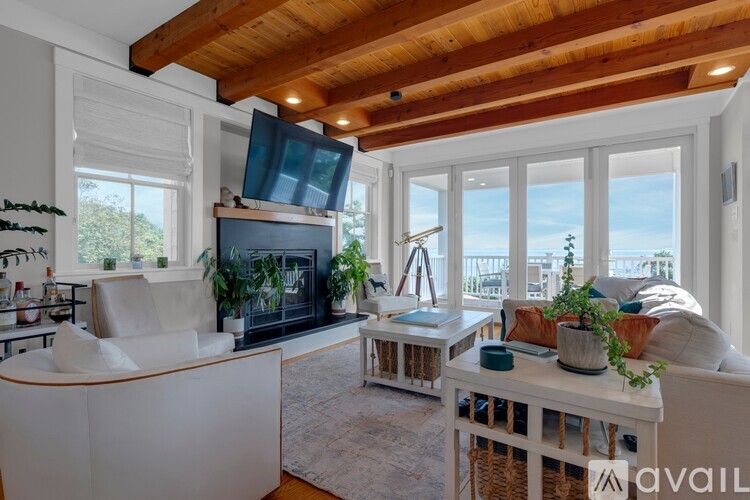 A living room with a white sofa and a wooden ceiling.