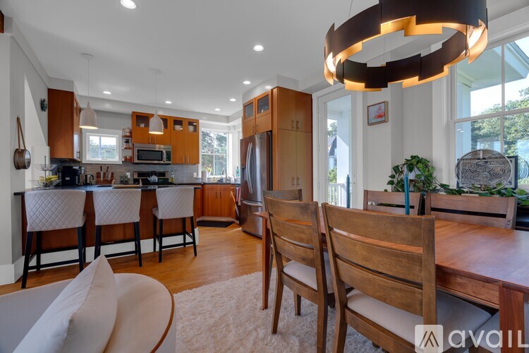 A modern kitchen with wooden chairs and a dining table.