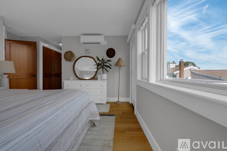 A bedroom with a large bed and a window overlooking a building.