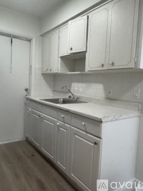 A kitchen with white cabinets and a white dishwasher.