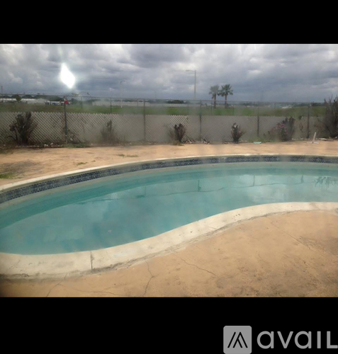 A small pool with a brownish edge and a cloudy sky in the background.