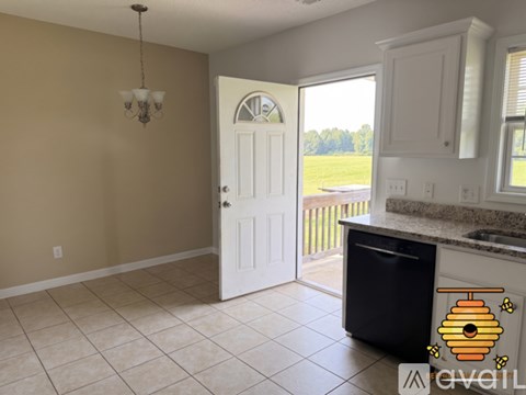 A kitchen with a black dishwasher and a white door.