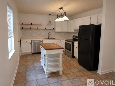 A kitchen with black appliances and white cabinets.