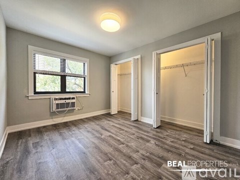 A room with a window and a fan on the window sill.