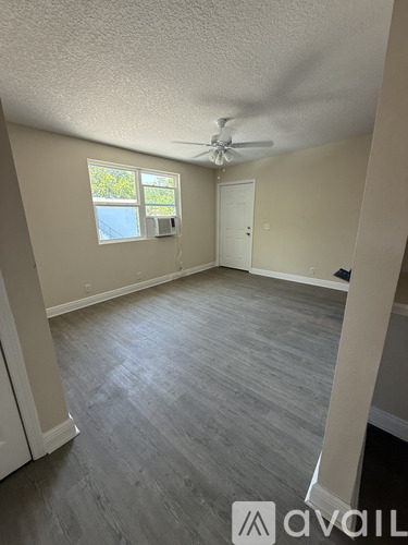A room with a ceiling fan and a window with blinds.