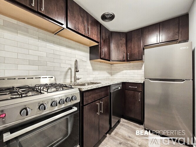A kitchen with a stove, refrigerator, and cabinets.