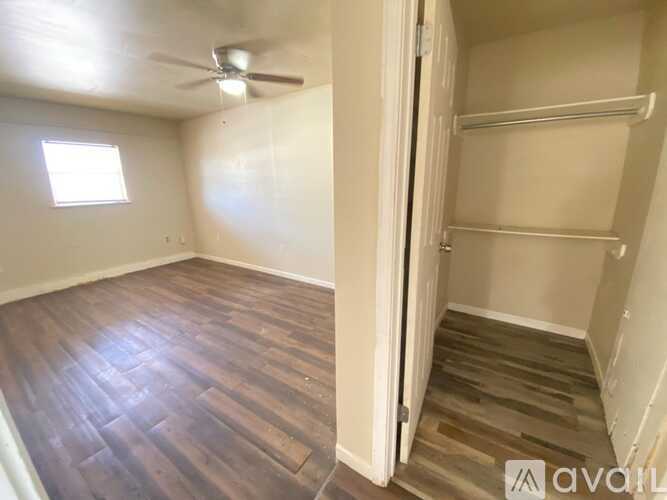 A room with a wooden floor and a ceiling fan.