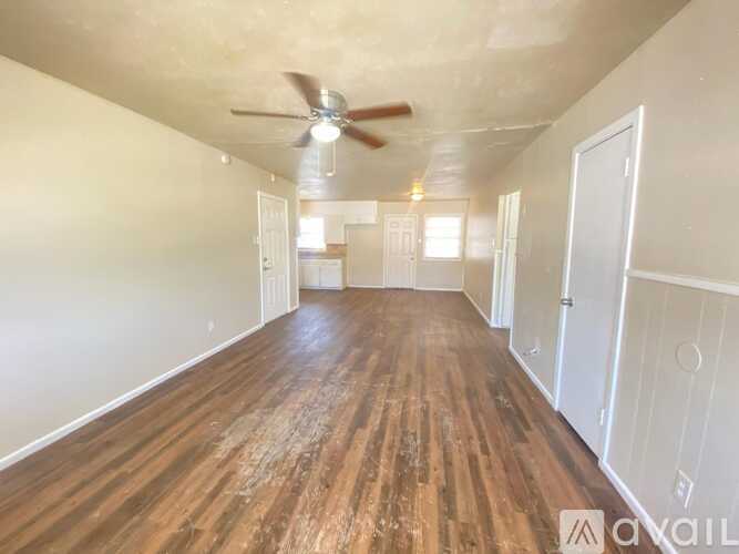 A room with wooden floors and a ceiling fan.
