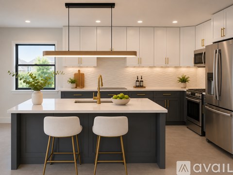 A modern kitchen with white cabinets and a large island with two stools.