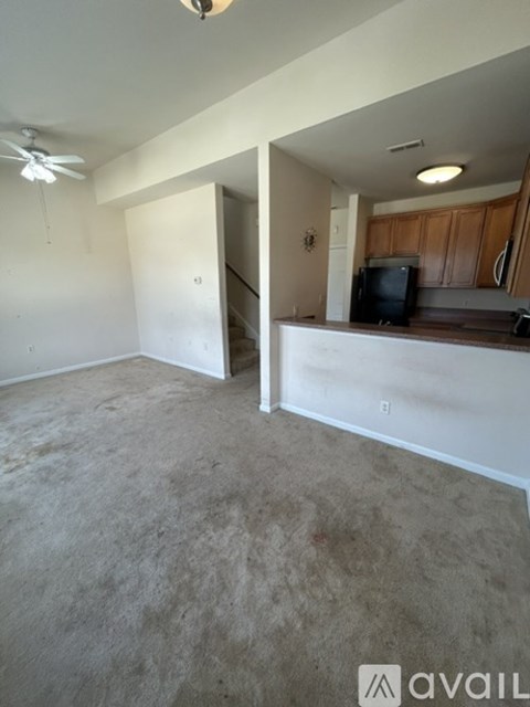 A living room with a television and a staircase leading to the upper floor.