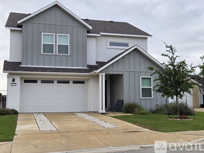 A two-story house with a garage and a driveway.
