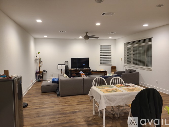 A living room with a couch, chairs, and a dining table.