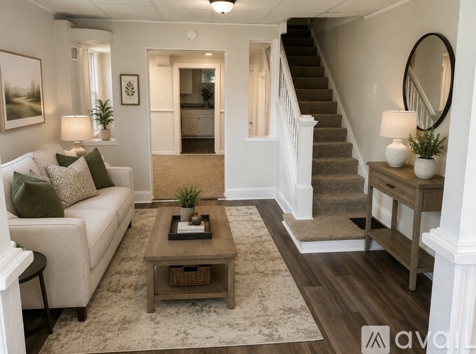 A living room with a couch, coffee table, and staircase.