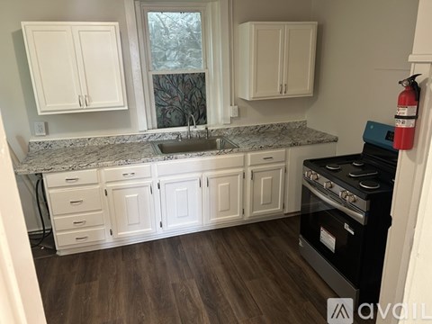 A kitchen with white cabinets and a black stove top oven.