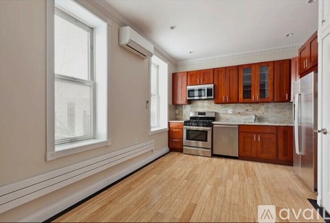 A kitchen with wooden floors and brown cabinets.