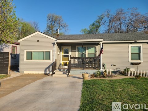 A house with a grey exterior and a yellow door.