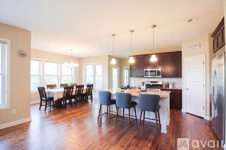 A kitchen with a dining table and chairs.