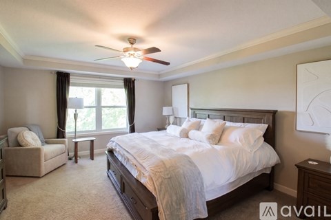 A bedroom with a large bed and a ceiling fan.