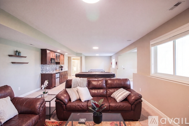 A living room with brown leather couches and a glass coffee table.