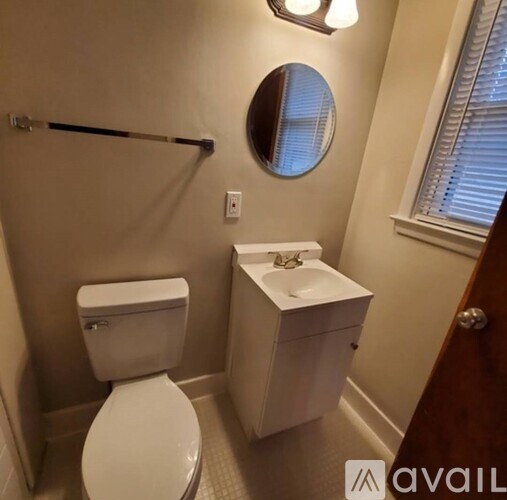 A white toilet and sink in a small bathroom.
