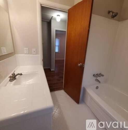 A bathroom with a white bathtub and a wooden door.