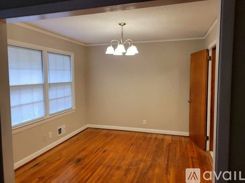 A room with wooden floors and a chandelier.