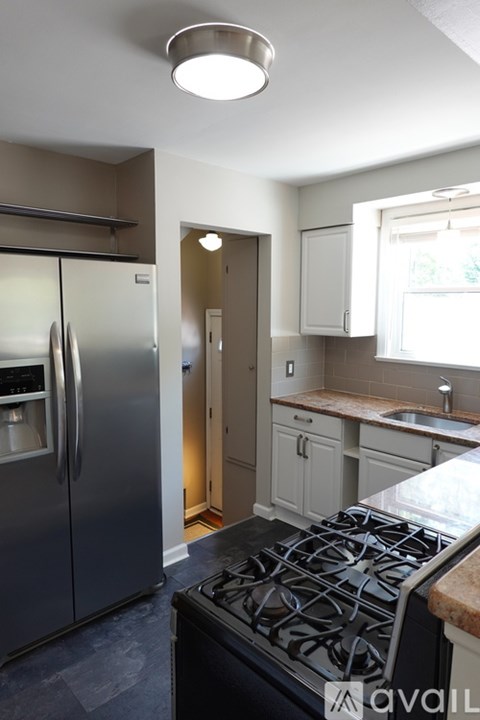 A kitchen with a stove top oven and a refrigerator.