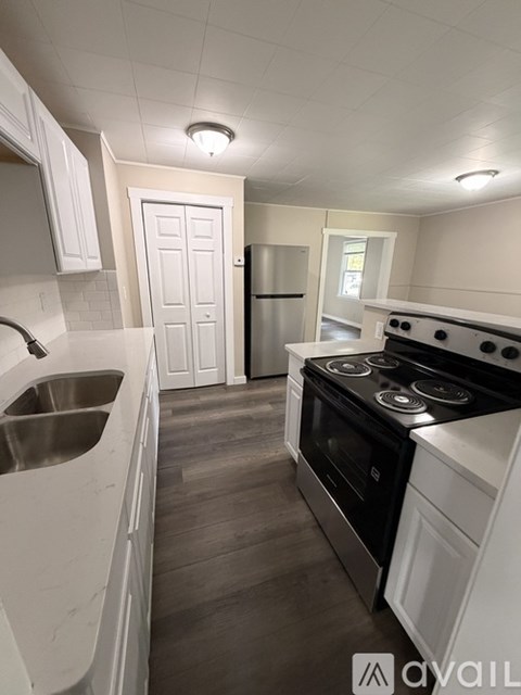 A kitchen with white cabinets and a black stove top oven.