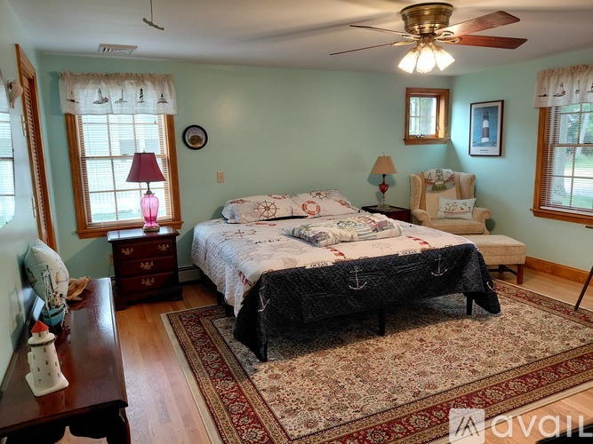 A bedroom with a large bed and a ceiling fan.
