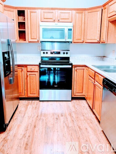 A kitchen with wooden cabinets and a black stove top oven.