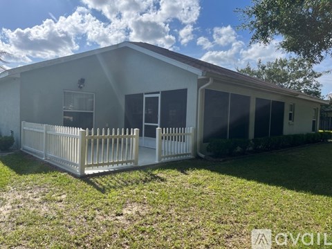 A white house with a porch and a fence.