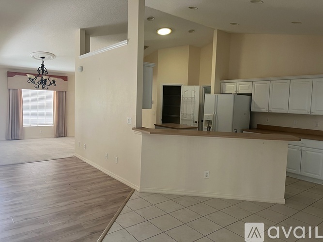 A kitchen area with white cabinets and a wooden countertop.