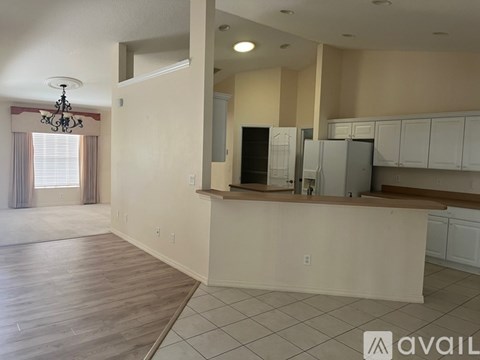 A kitchen area with white cabinets and a wooden countertop.