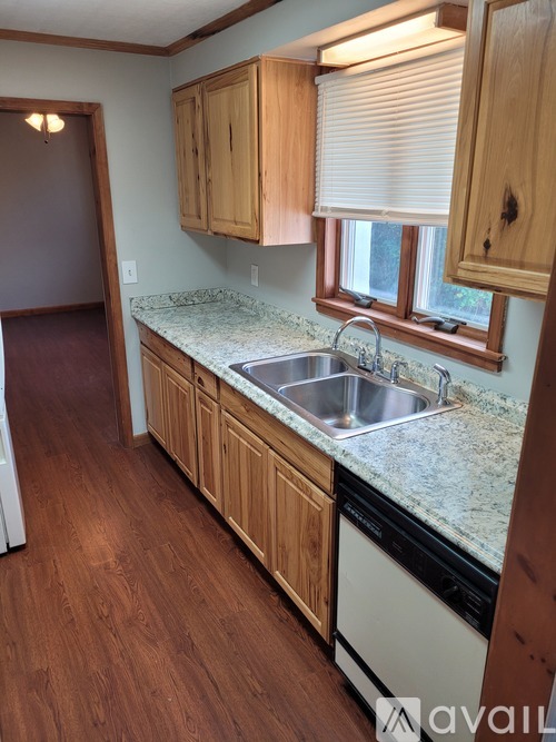 A kitchen with wooden cabinets and a granite countertop.