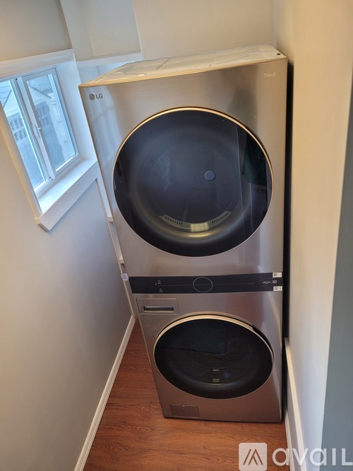 A silver LG washing machine in a narrow space.