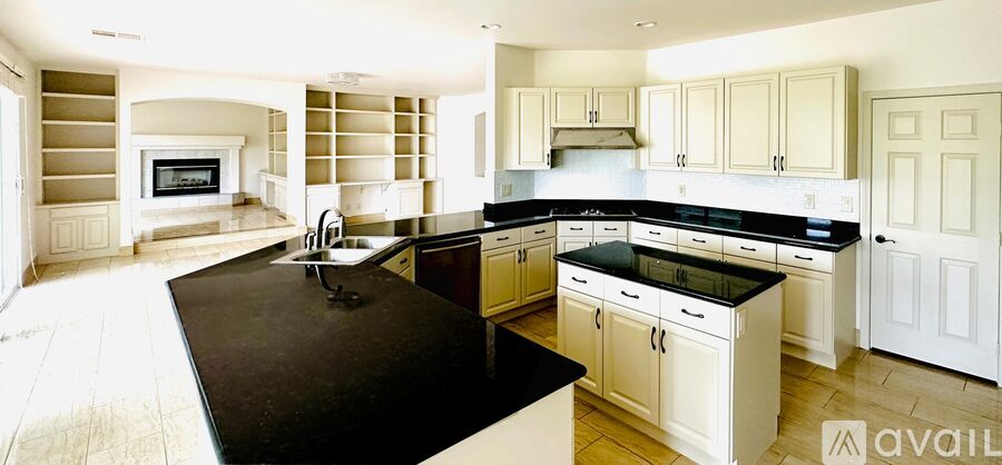 A kitchen with a black counter top and white cabinets.