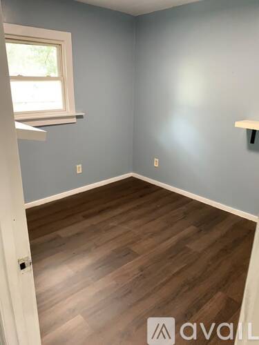A room with wooden flooring and a window.