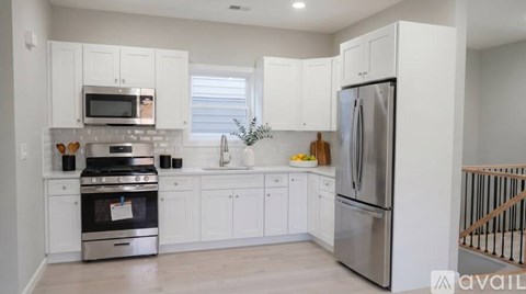 A kitchen with white cabinets and stainless steel appliances.