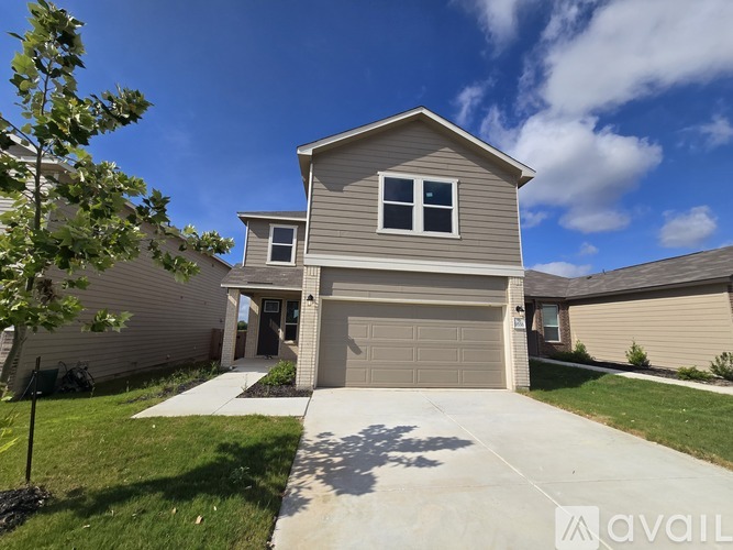 A house with a garage and a driveway in front.