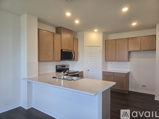 A kitchen with a white counter and wooden cabinets.