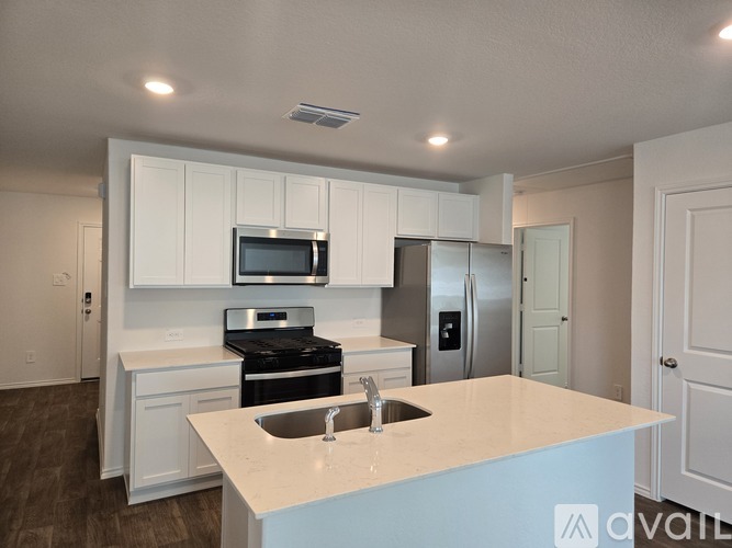 A kitchen with white cabinets and a blue island.